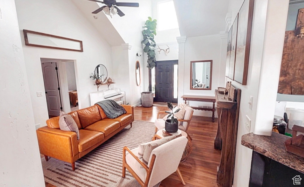 Living area featuring high vaulted ceiling, a ceiling fan, and wood finished floors