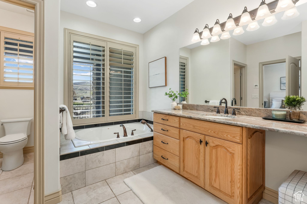 Bathroom featuring tile patterned flooring, a bath, toilet, and vanity