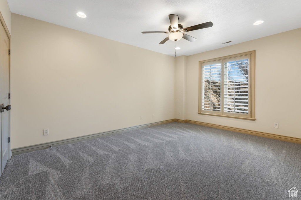 Carpeted empty room featuring baseboards, a ceiling fan, visible vents, and recessed lighting