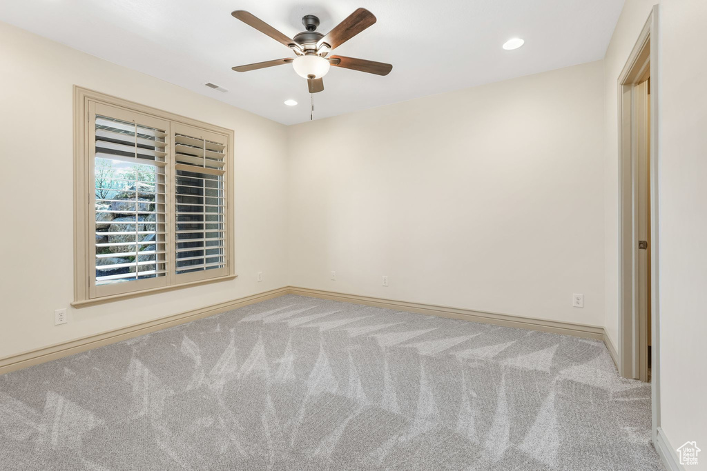 Carpeted empty room with baseboards, recessed lighting, ceiling fan, and visible vents