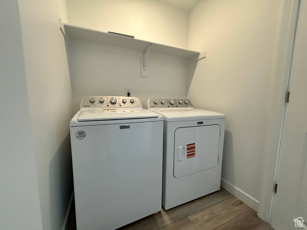 Laundry area featuring laundry area, wood finished floors, and separate washer and dryer