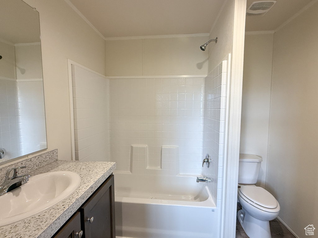 Bathroom featuring ornamental molding, toilet, shower / washtub combination, vanity, and visible vents