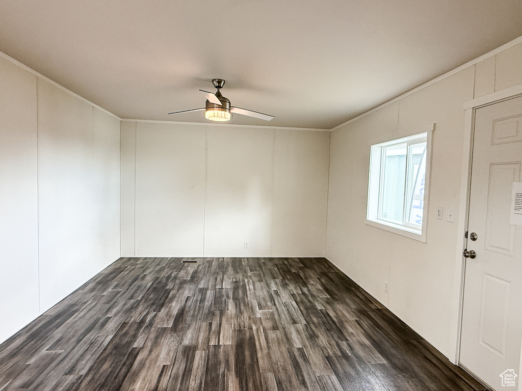 Spare room featuring ornamental molding, ceiling fan, and wood finished floors