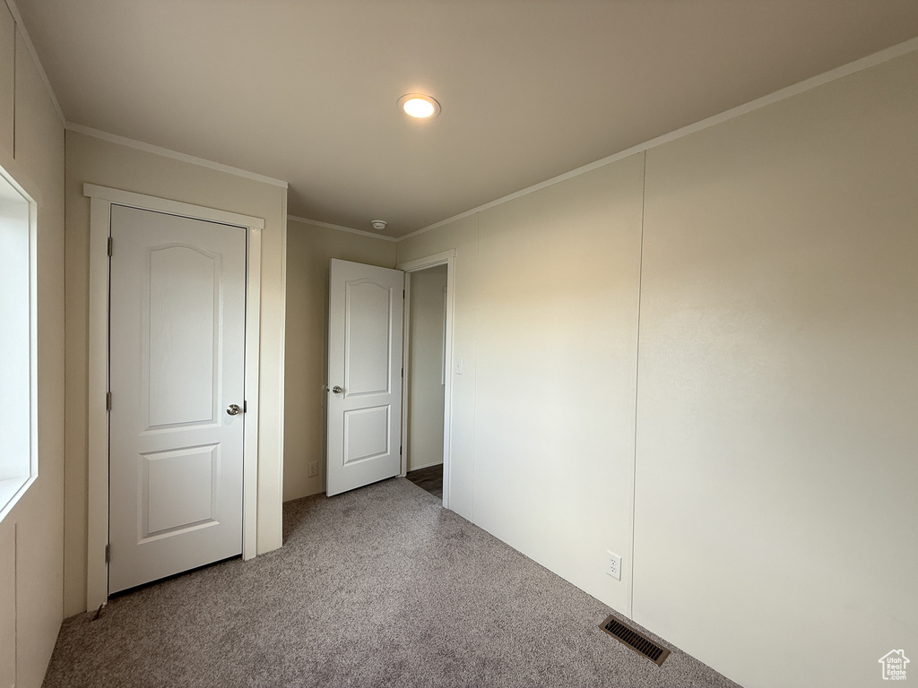 Unfurnished bedroom featuring carpet, visible vents, crown molding, and recessed lighting