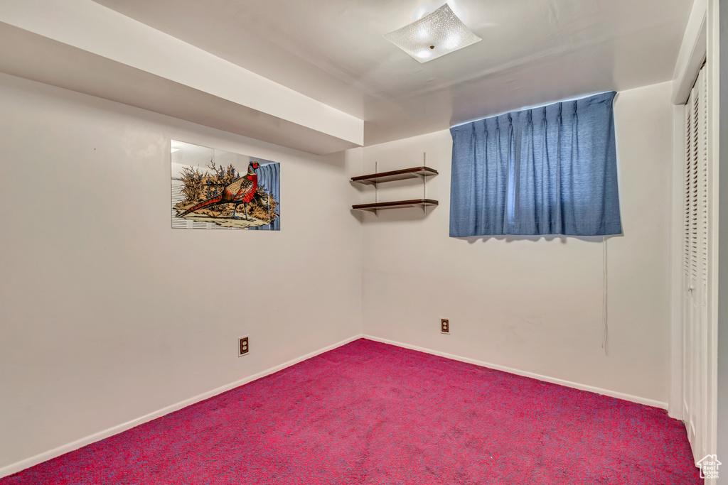 Interior space featuring baseboards and dark carpet