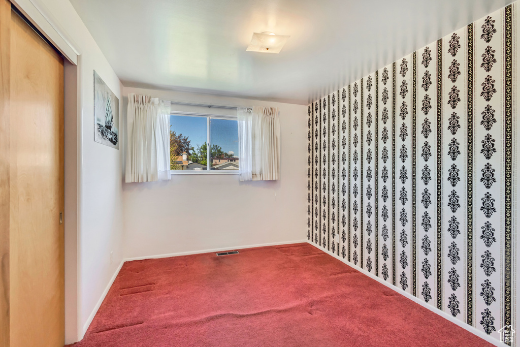 Empty room with baseboards, carpet, and visible vents