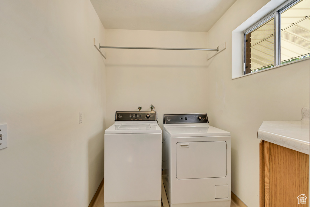 Washroom with baseboards, laundry area, and washer and dryer