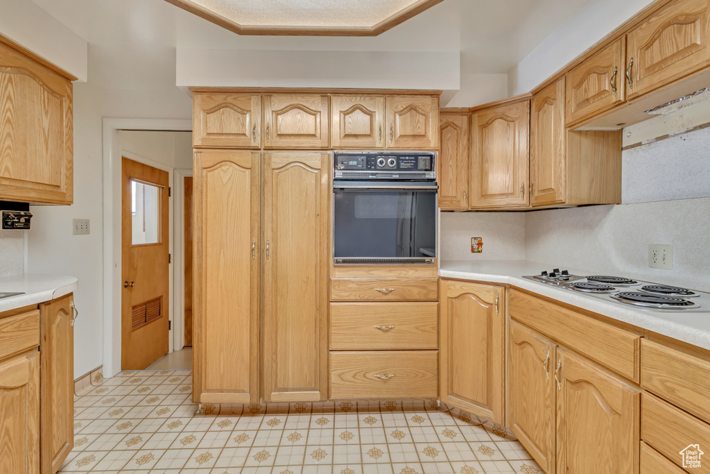 Kitchen featuring light countertops, visible vents, electric stovetop, and oven