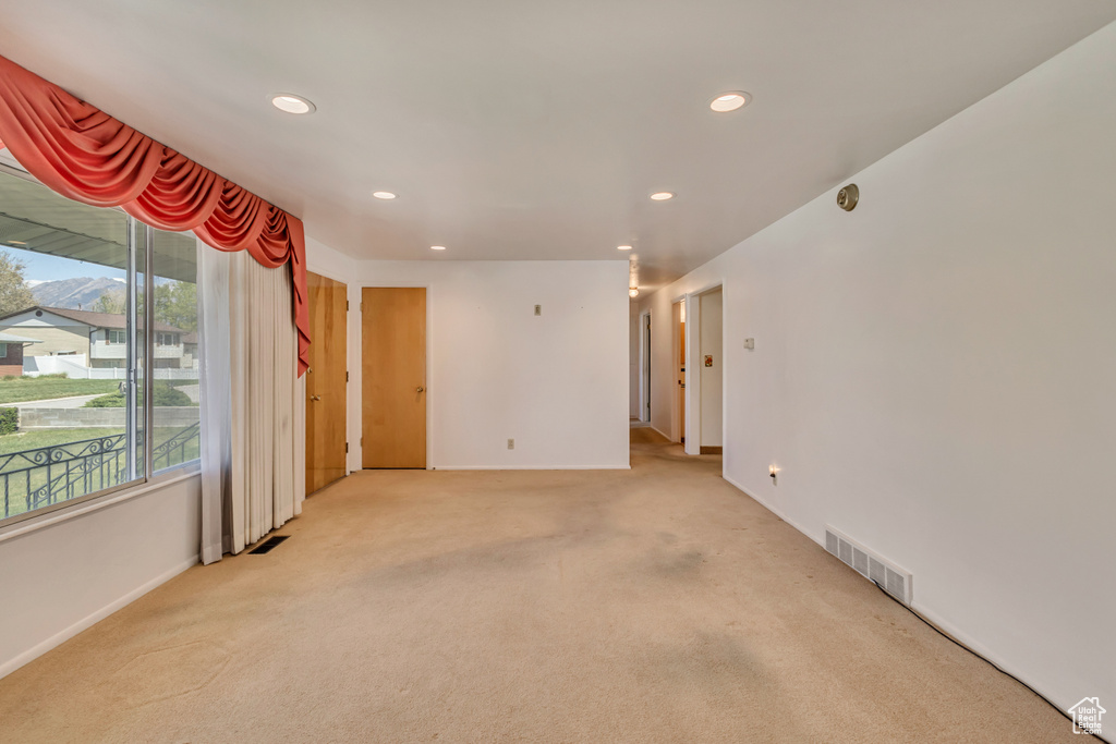 Empty room featuring recessed lighting, baseboards, visible vents, and light carpet