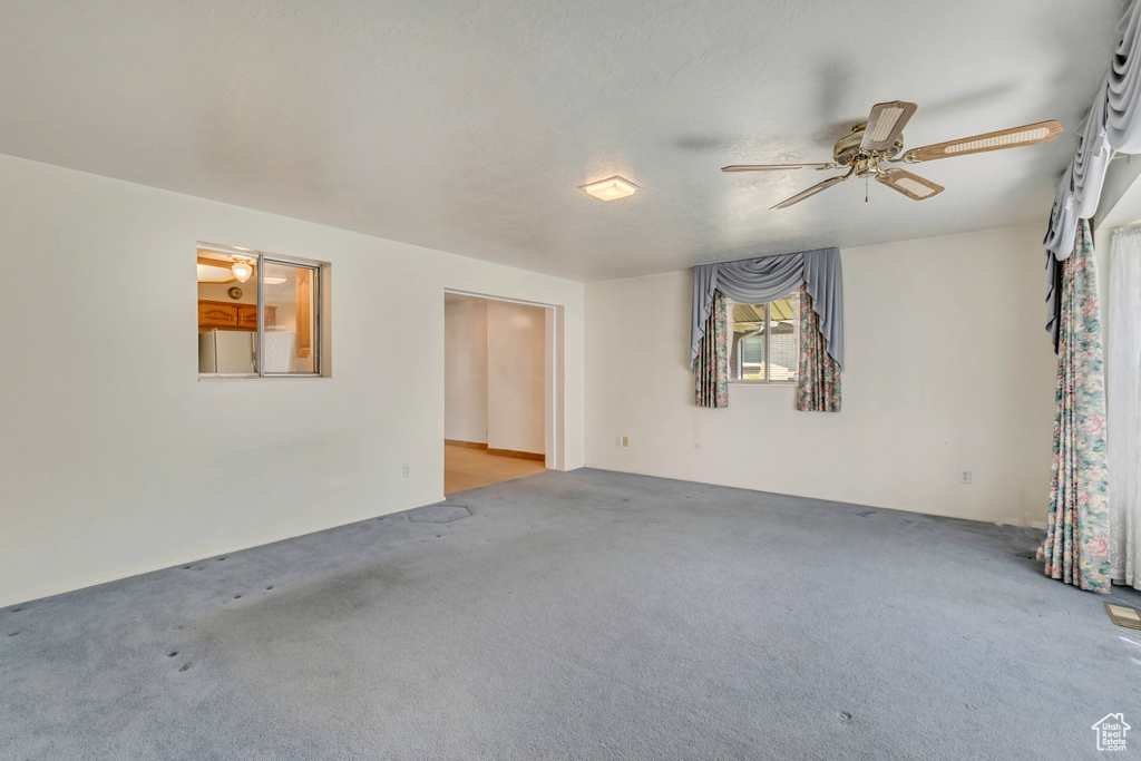 Empty room featuring carpet floors and ceiling fan