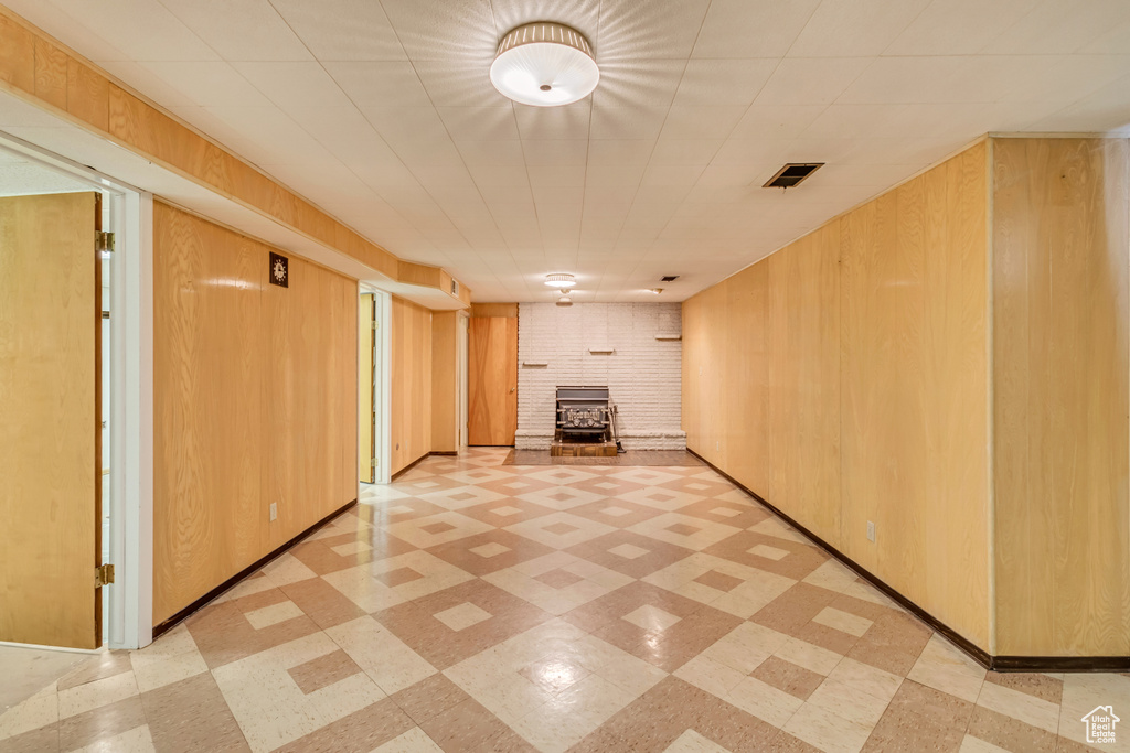 Corridor with wooden walls, visible vents, and light floors