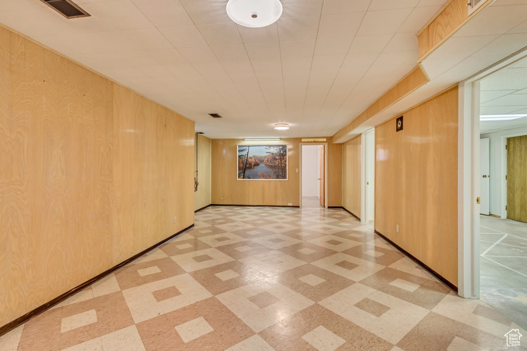 Interior space featuring wooden walls, light floors, and visible vents