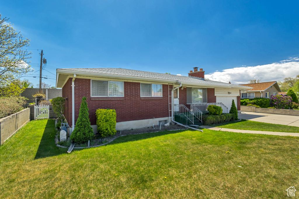 View of front of property with an attached garage, fence, brick siding, and concrete driveway