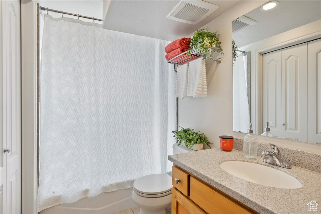 Bathroom with toilet, shower / tub combo with curtain, visible vents, and vanity