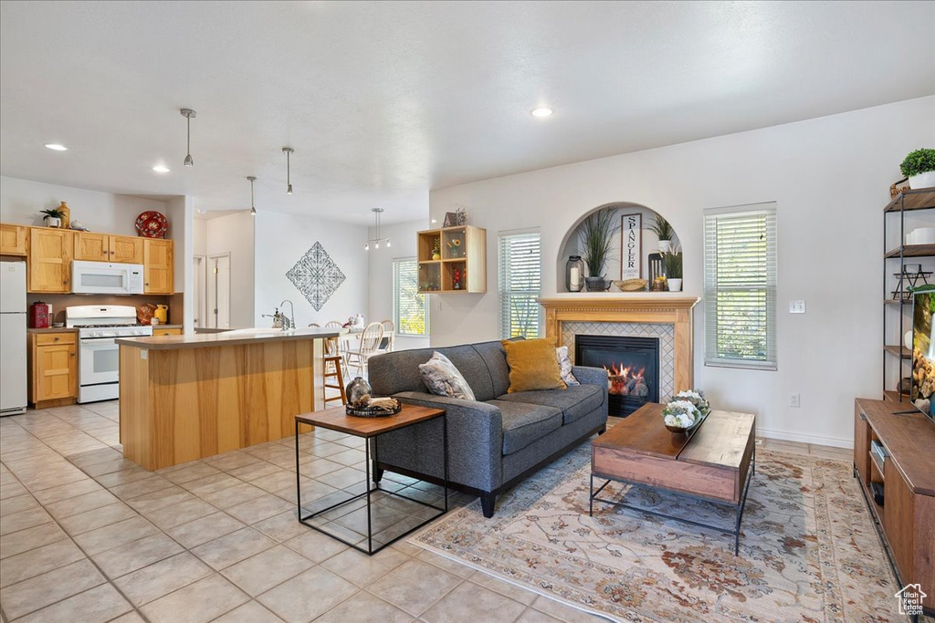 Living area featuring light tile patterned flooring, a tiled fireplace, and recessed lighting