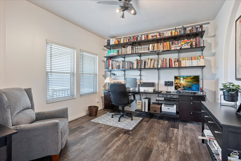 Office space with dark wood-style flooring, visible vents, a ceiling fan, and baseboards