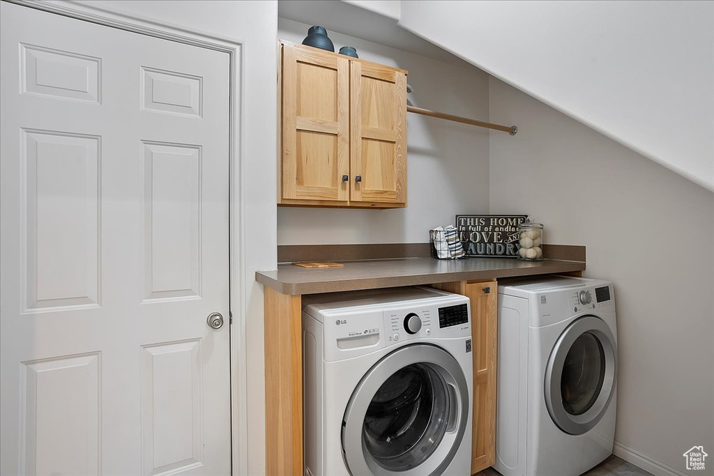 Washroom with washing machine and clothes dryer and cabinet space