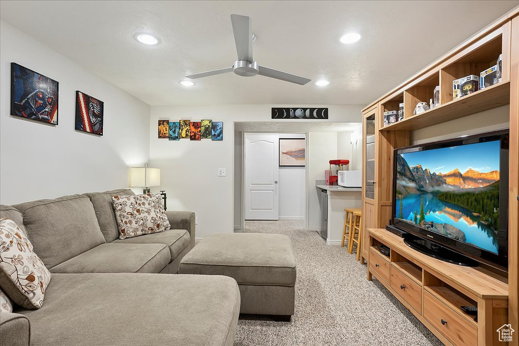 Living room with a ceiling fan, recessed lighting, and light carpet
