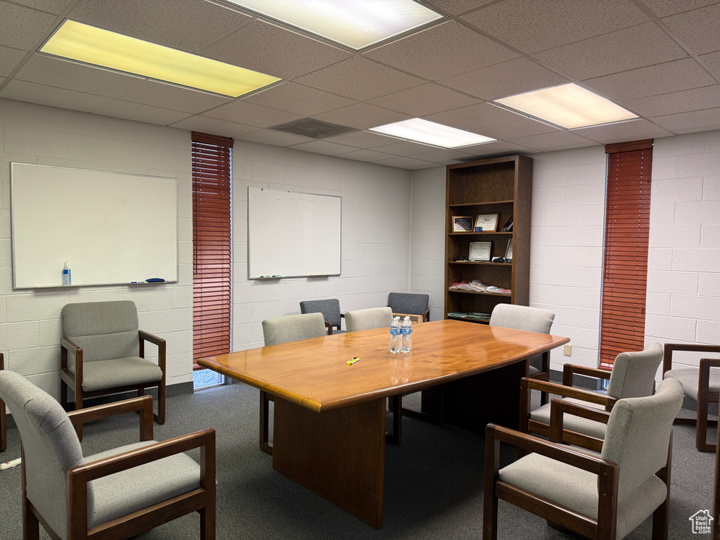 Office featuring carpet floors, a drop ceiling, and concrete block wall