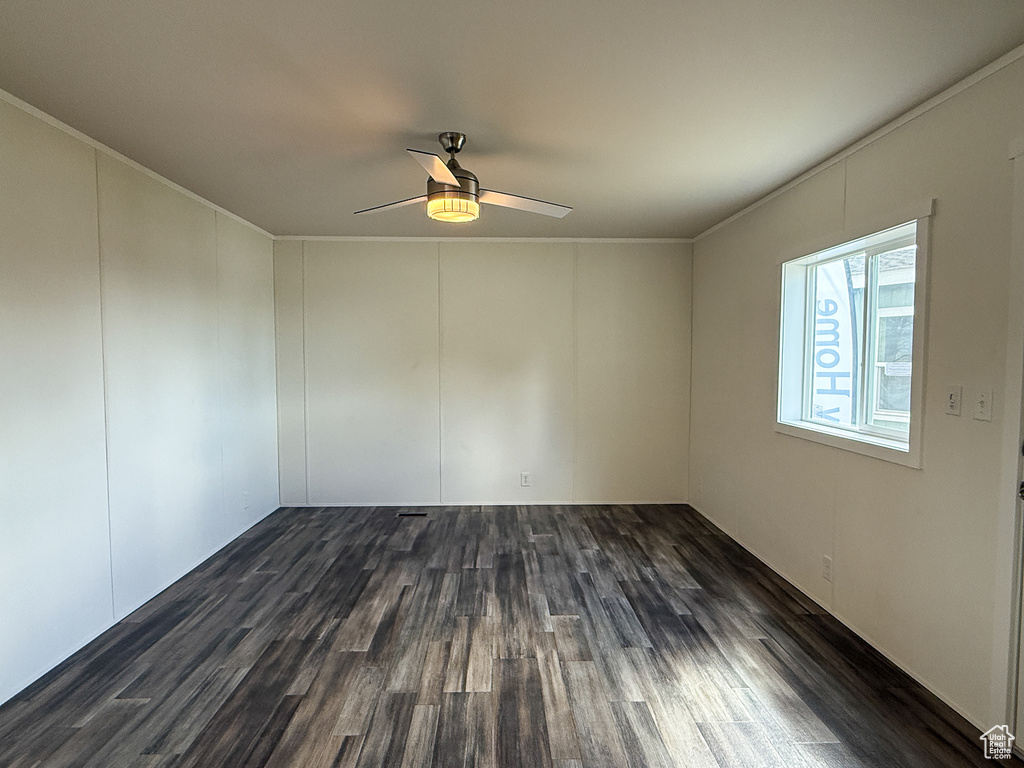 Unfurnished room with ornamental molding, ceiling fan, and dark wood-type flooring