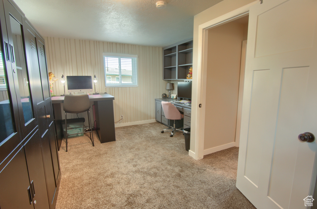 Office area with baseboards and light carpet