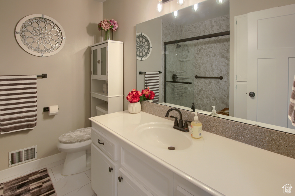 Bathroom with visible vents, vanity, toilet, baseboards, and a shower stall