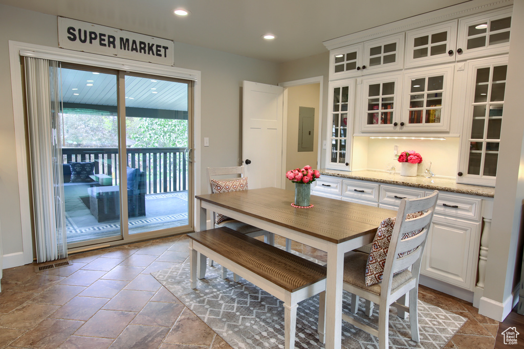 Dining room featuring stone tile floors, recessed lighting, and electric panel
