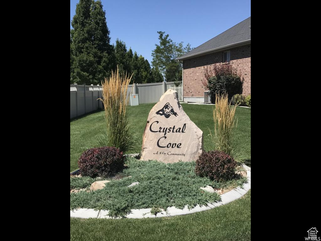 Community / neighborhood sign featuring fence and a yard