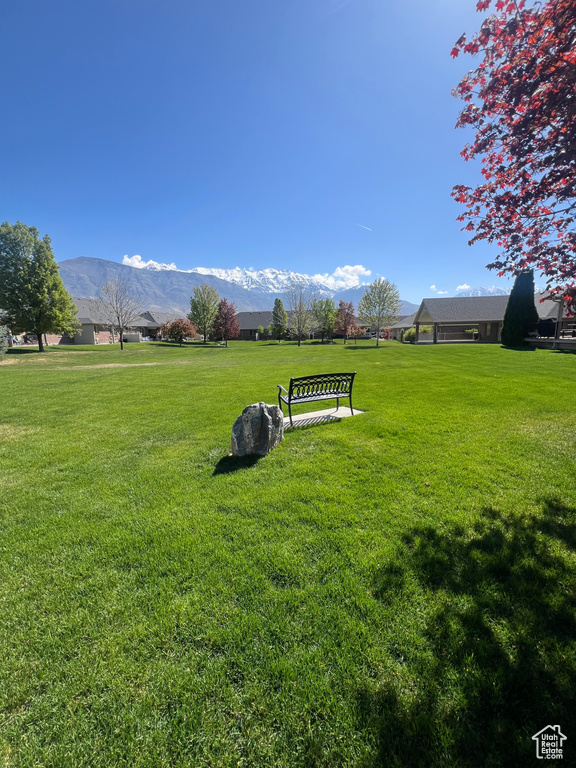 Surrounding community with a yard and a mountain view