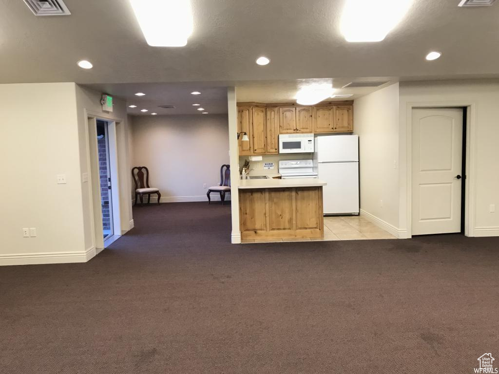 Kitchen with white appliances, recessed lighting, light colored carpet, and visible vents