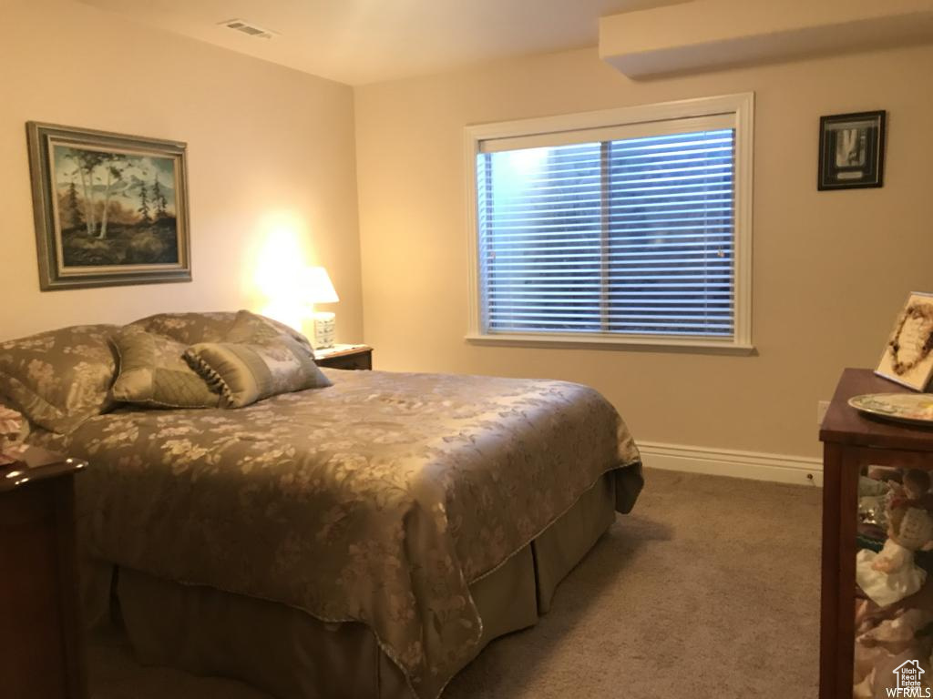 Carpeted bedroom with visible vents and baseboards
