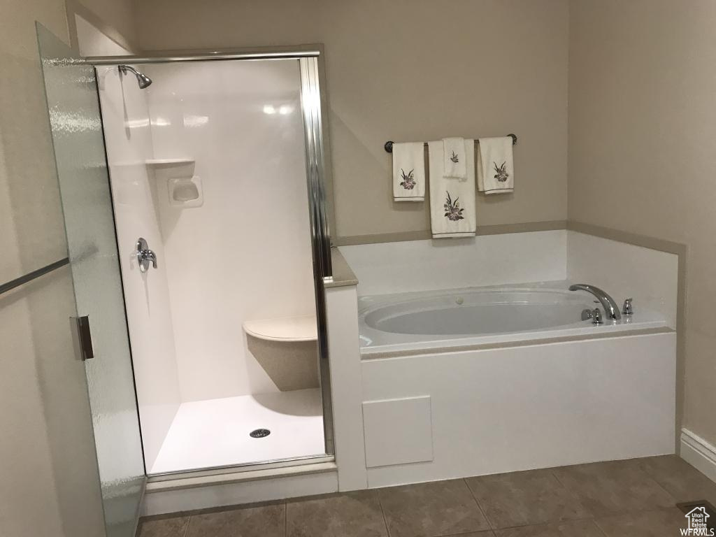 Full bath featuring tile patterned flooring, a bath, and a shower stall