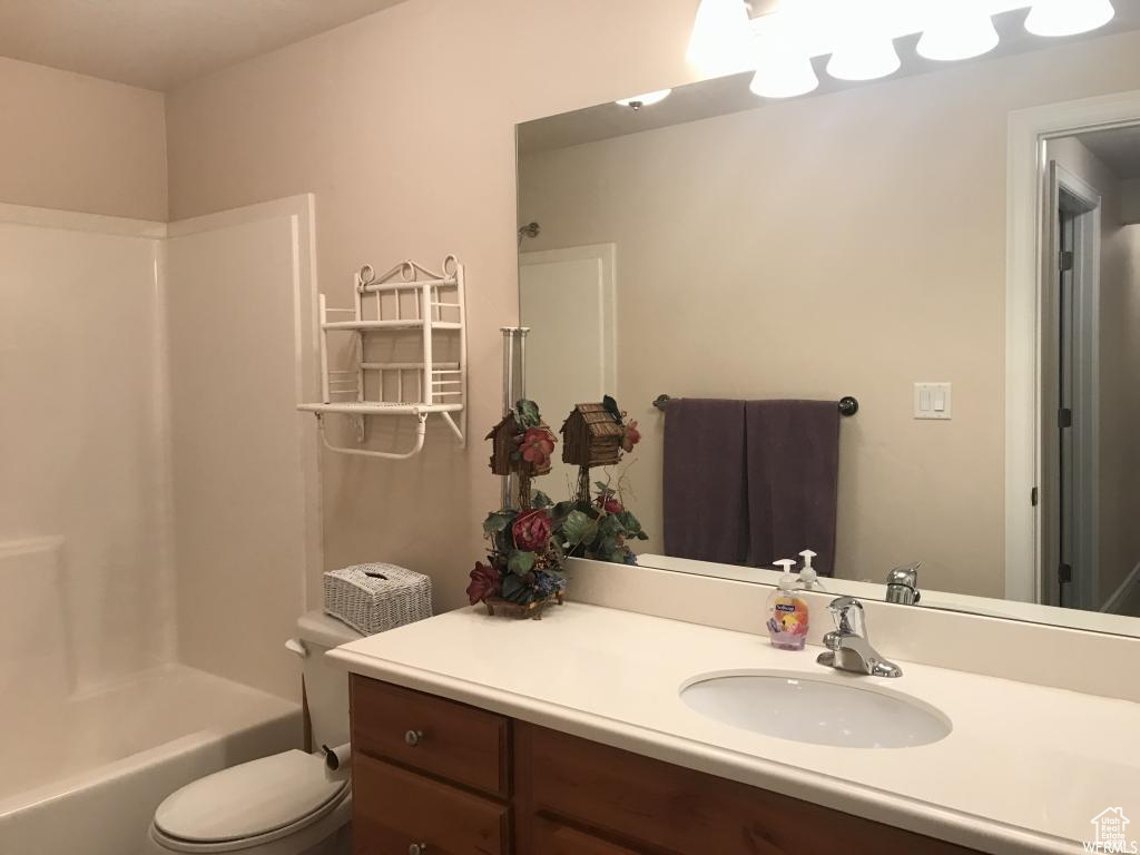 Bathroom with vanity, shower / bath combination, and toilet