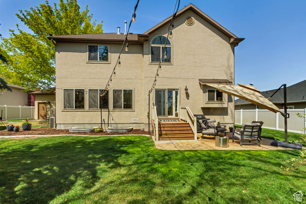 Back of property featuring fence, a patio, stucco siding, a yard, and an outdoor living space