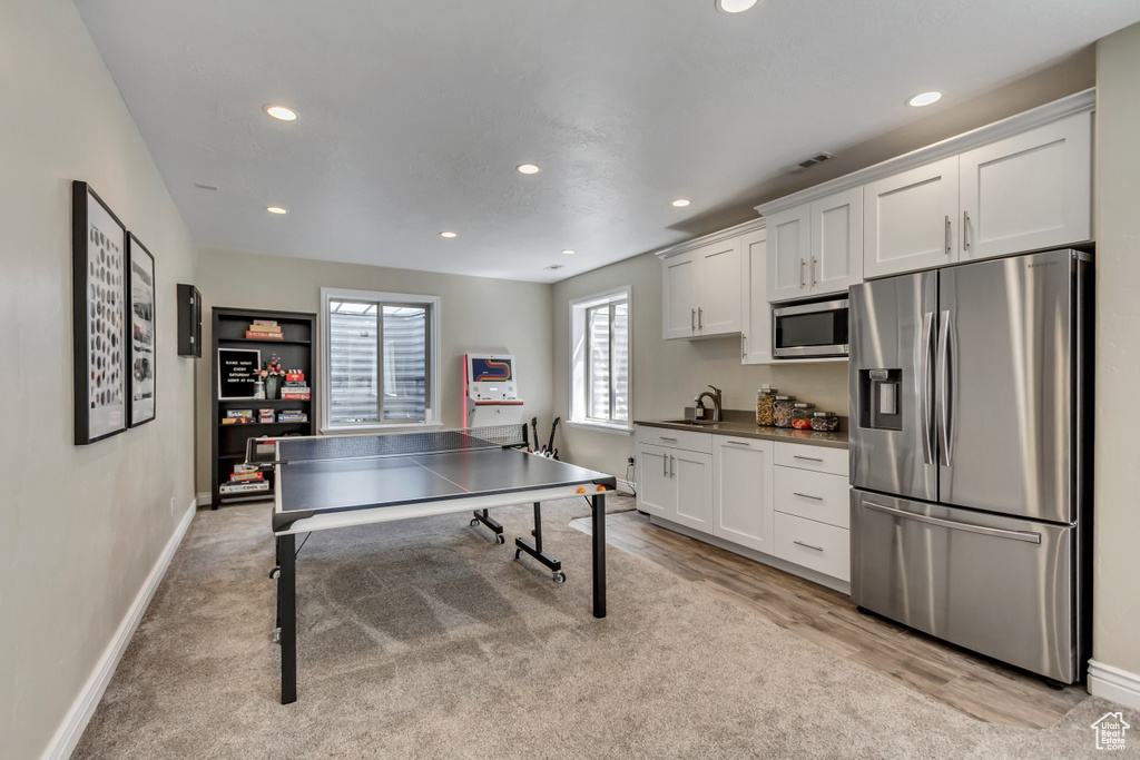 Recreation room featuring recessed lighting, a sink, light wood-style floors, and baseboards
