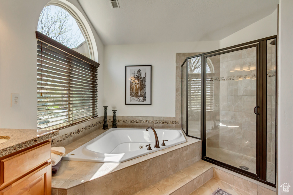 Bathroom with a stall shower, a wealth of natural light, and a garden tub