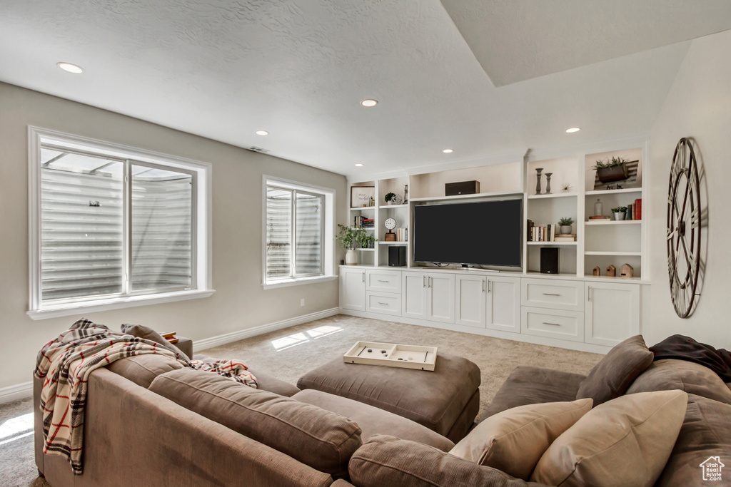 Living area featuring baseboards, recessed lighting, and light colored carpet