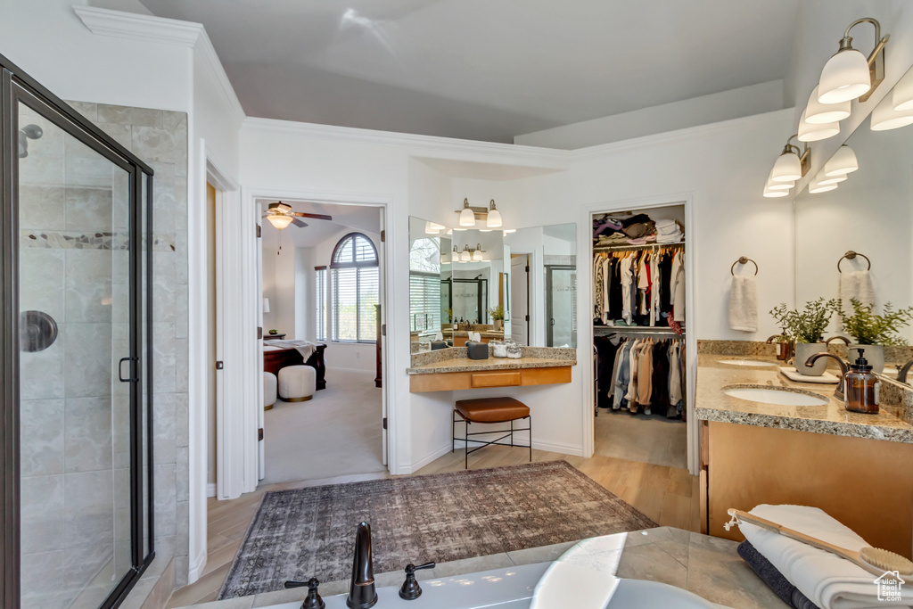 Full bathroom featuring ornamental molding, a shower stall, vanity, and a spacious closet