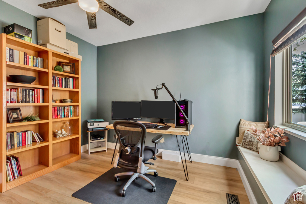 Office area featuring visible vents, a ceiling fan, light wood finished floors, and baseboards