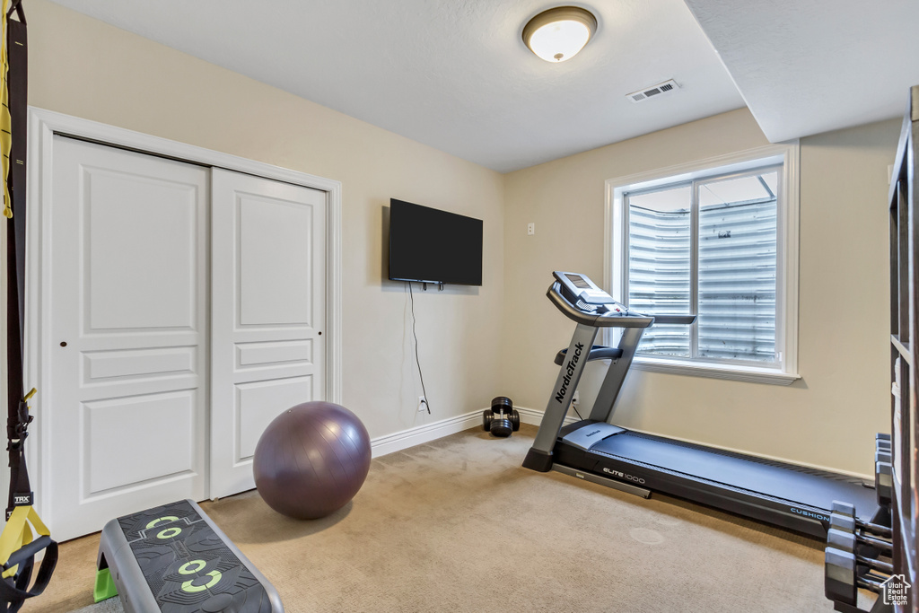 Workout area with baseboards, visible vents, and carpet