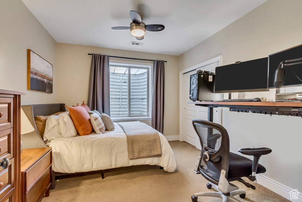 Bedroom with baseboards, visible vents, a ceiling fan, and light colored carpet