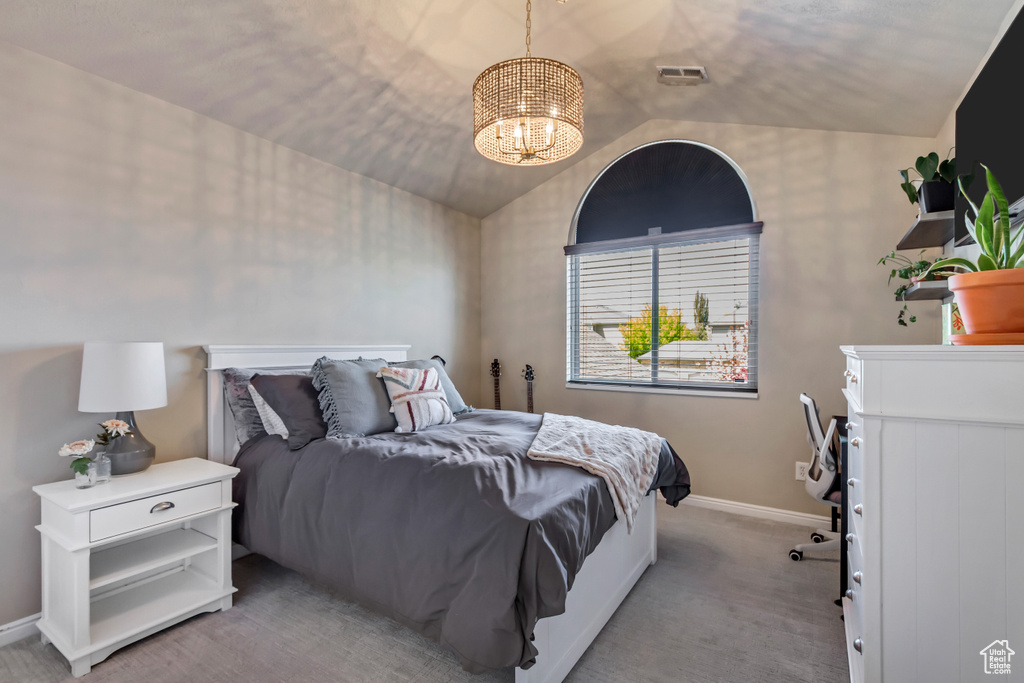 Bedroom with a chandelier, baseboards, light colored carpet, and vaulted ceiling