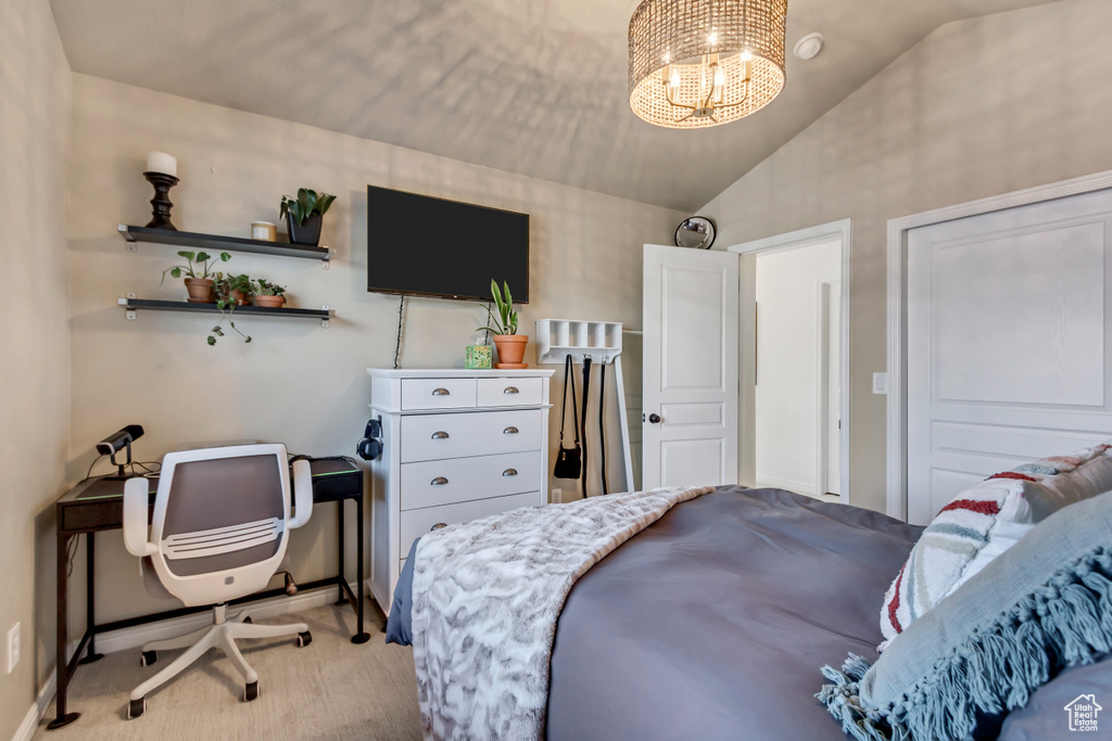Bedroom featuring a notable chandelier, light colored carpet, and vaulted ceiling