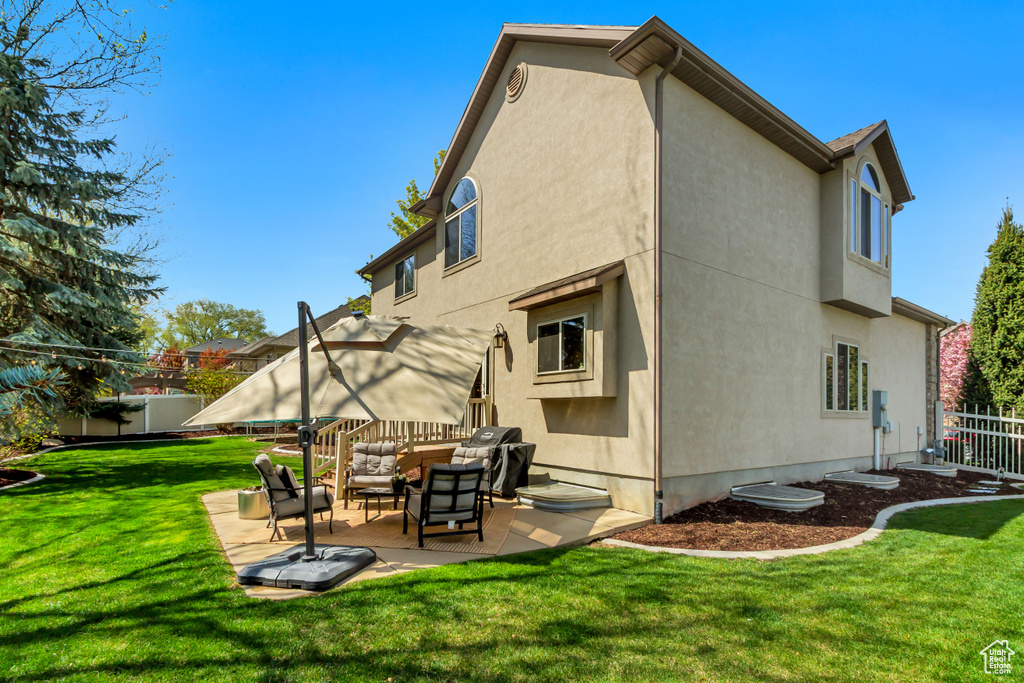 Back of house with fence, stucco siding, a patio, and an outdoor hangout area