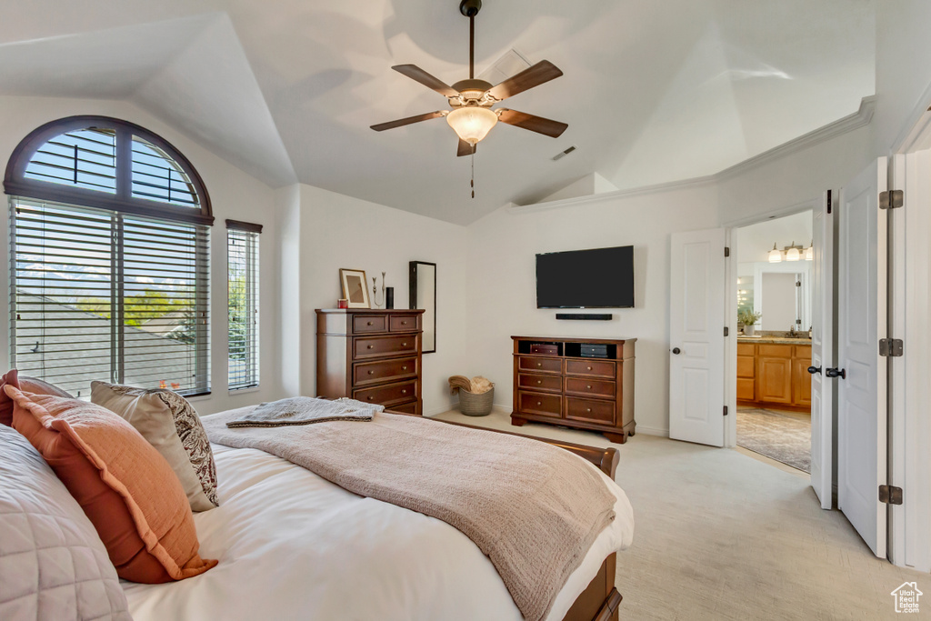 Bedroom featuring ceiling fan, ensuite bathroom, high vaulted ceiling, and light carpet