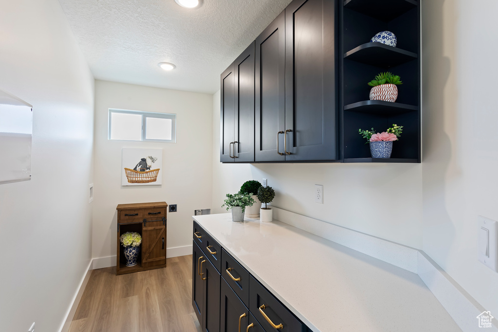 Bar featuring recessed lighting, a textured ceiling, baseboards, and light wood-style floors