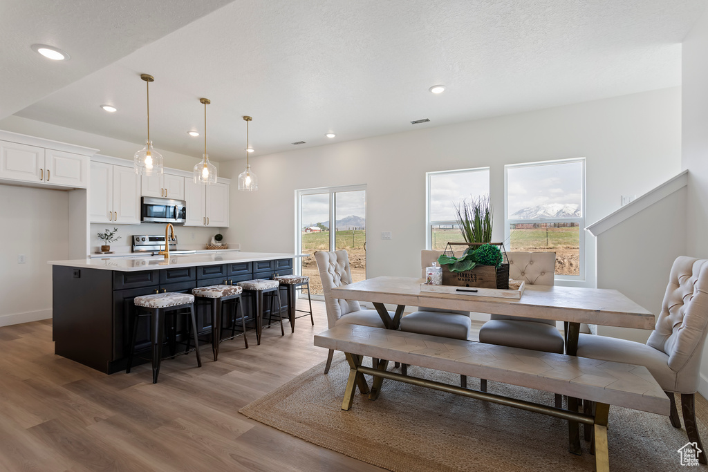 Dining space with recessed lighting, light wood finished floors, and visible vents
