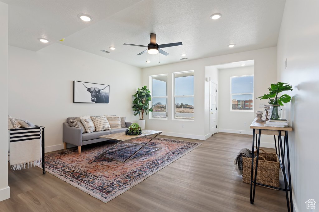 Living room featuring baseboards, recessed lighting, ceiling fan, and wood finished floors