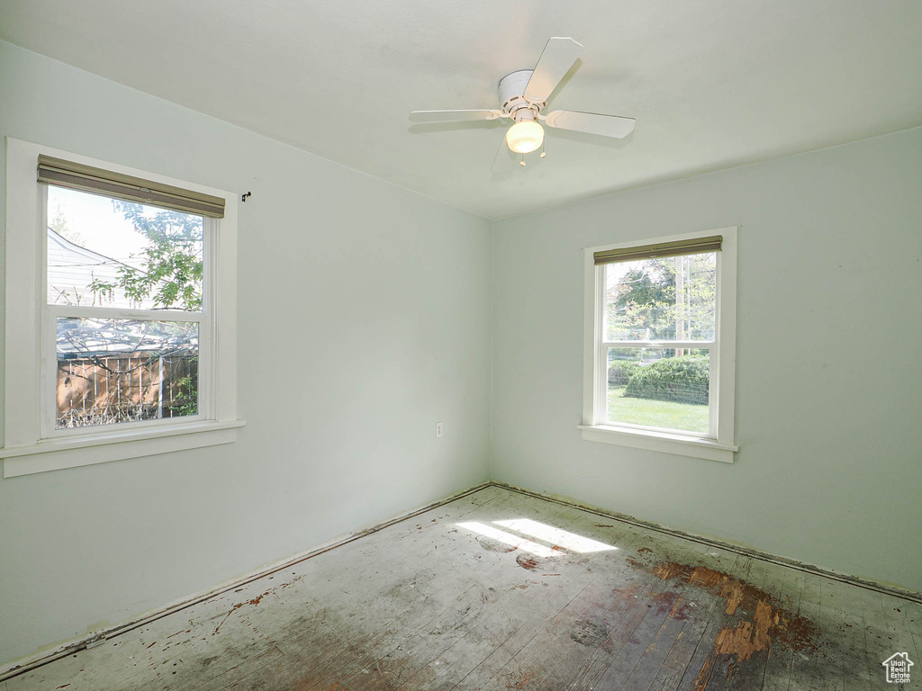 Empty room with plenty of natural light and a ceiling fan