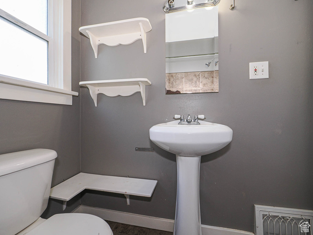Bathroom with a sink, baseboards, and toilet